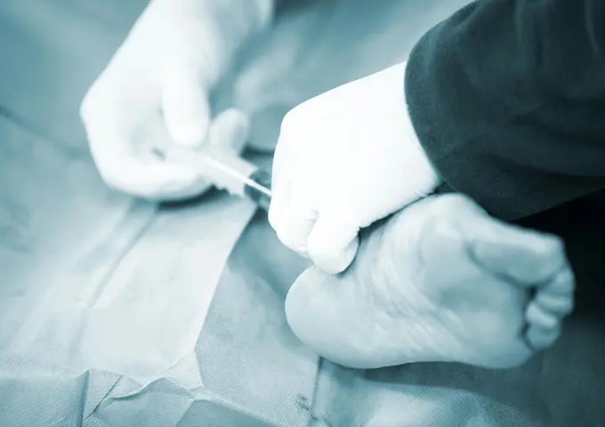 A person cutting something with scissors on top of a table.